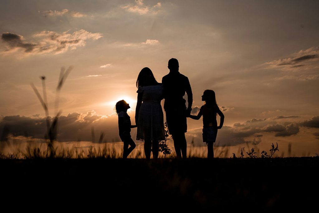 Family law services; a family of four stands in front of a sunset.